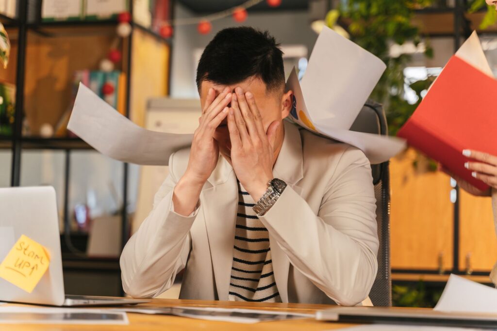 Hombre estresado trabajando frente a una computadora