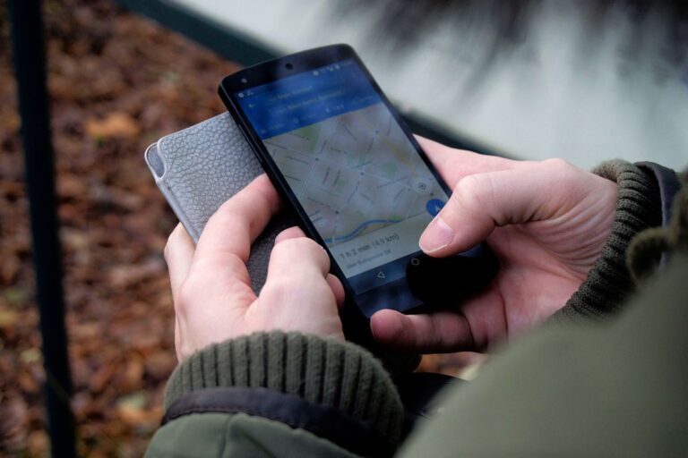 Persona usando Google Maps en su celular para buscar un negocio cerca